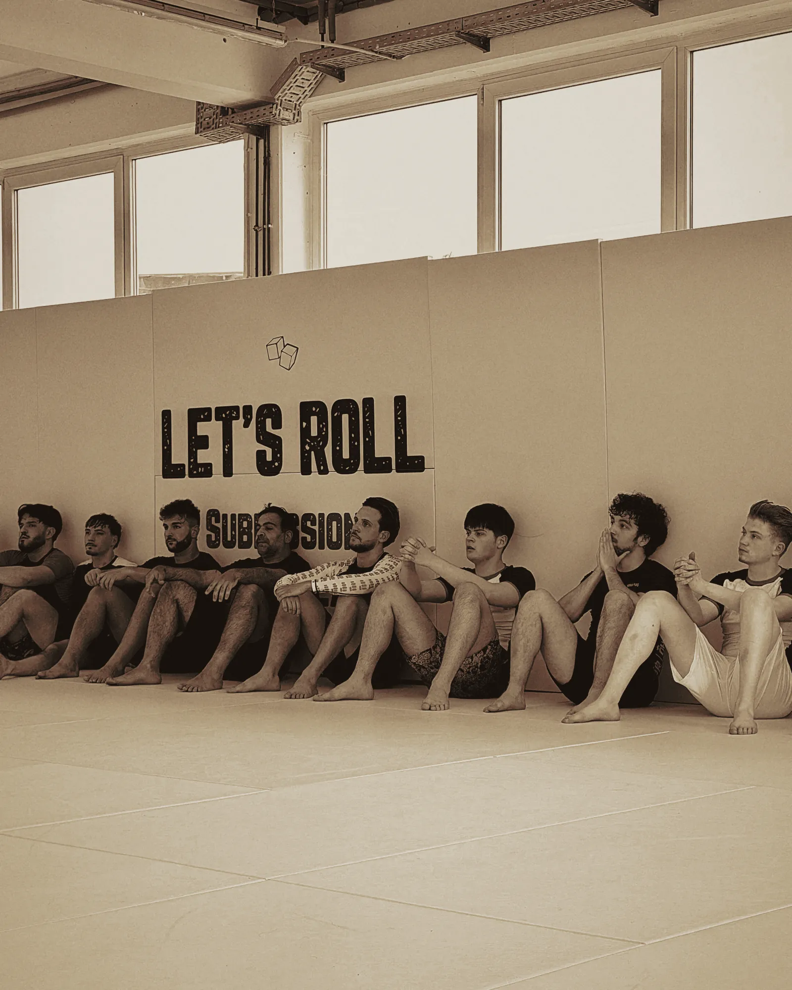 Das Let's-Roll-Team sitzt aufgereiht an der Wand mit dem LET'S-ROLL-Schriftzug.