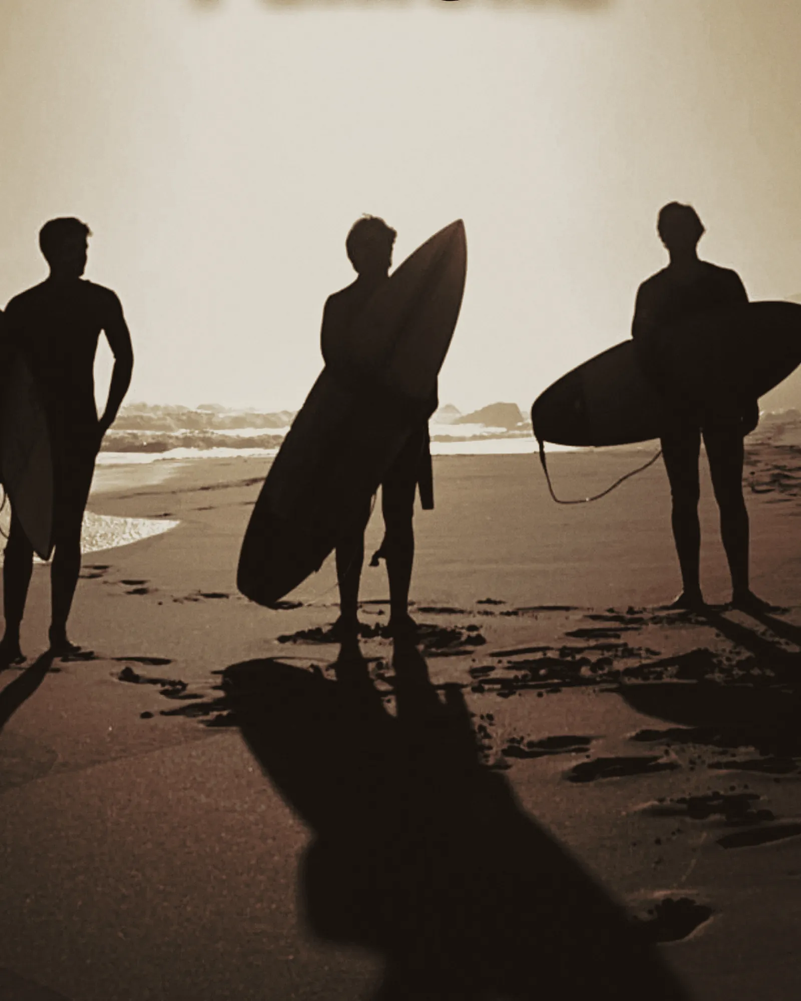 Drei Surfer mit Boards am Strand von Peniche.
