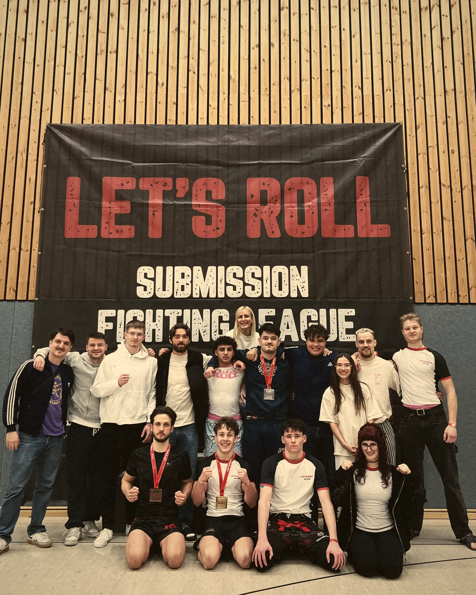 Gruppenfoto der Teilnehmenden vor dem Banner der Submission Fighting League.
